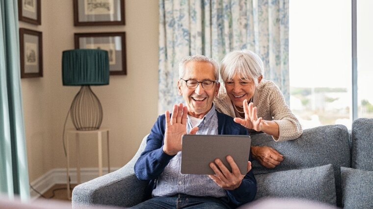 Happy senior couple doing video call at home